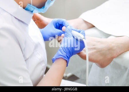 Master forme podologica i chiodi . Paziente di sesso maschile nel processo di hardware procedura di pedicure. Il concetto di cura del corpo. Close up, il fuoco selettivo Foto Stock