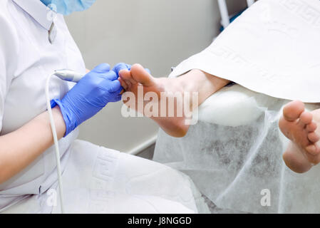 Master forme podologica i chiodi . Paziente di sesso maschile nel processo di hardware procedura di pedicure. Il concetto di cura del corpo. Close up, il fuoco selettivo Foto Stock