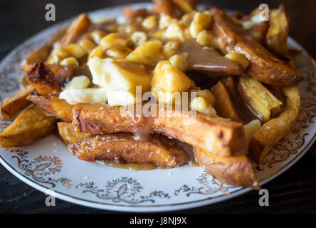 Una piastra di autentica, tradizionale Quebec poutine (patatine fritte, cagliata di formaggio e salsa) da Chartier Ristorante a Beaumont, Alberta, Canada. Foto Stock