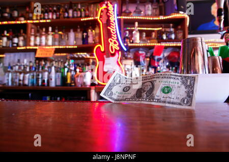 In paga le fatture del dollaro su un banco di bar Foto Stock