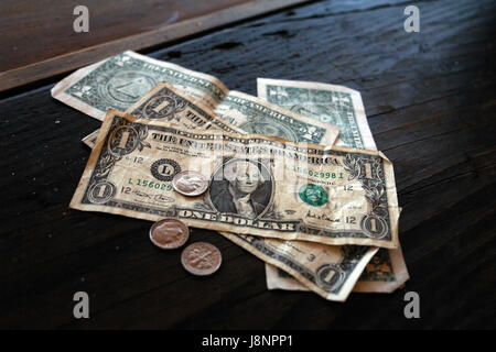 In paga le fatture del dollaro su un banco di bar Foto Stock