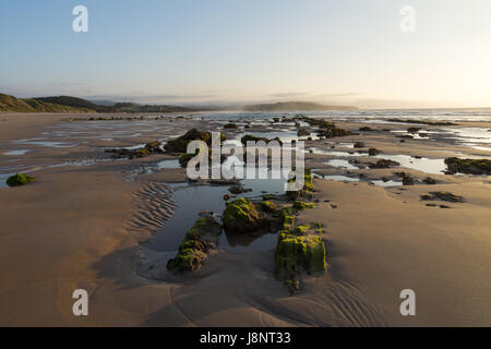 Rocce e piscine di roccia in sera la luce solare sulla playa Cabo / Guerra, San Vicente de la Barquera, Cantabria Foto Stock