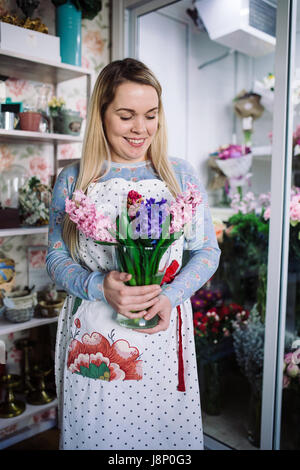 Donna fioraio azienda bouquet di giacinto indoor nel negozio di fiori Foto Stock
