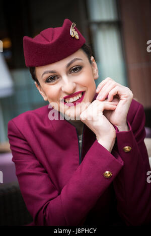 Attraente dama, Qatar assistente di volo equipaggio di cabina sulla sosta all'Aeroporto di Londra Heathrow sul volo successivo a Doha in Qatar. Foto Stock