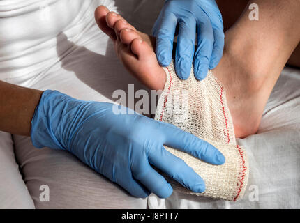 Close-up di un infermiere bendaggio di legatura sul piede di un paziente Foto Stock