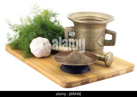 Ancora vita spezie,di pepe nero pestato ,calendula staminas in un vaso di rame su una tavola di legno su uno sfondo di una poppa stupa per la macinazione di spezie, bun Foto Stock