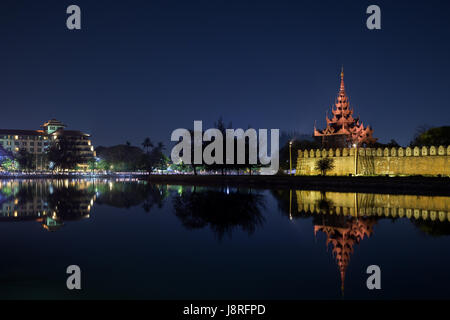 Città e cittadella di lit da parete, Bastione e pyatthat (spire) e fossato al royal Mandalay Palace a Mandalay, Myanmar (Birmania) a notte. Copia dello spazio. Foto Stock