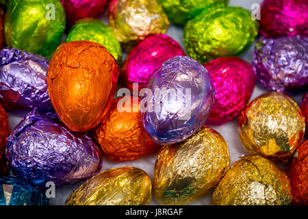 Vibrante avvolti a mano le uova di Pasqua di cioccolata in colori luminosi di carta stagnola Foto Stock