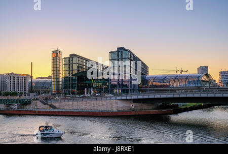 Berlino, Germania - 27 maggio 2017: Berlin Hauptbahnhof ( alla stazione principale di Berlino), il fiume Sprea con la barca con il tramonto sullo sfondo del cielo Foto Stock