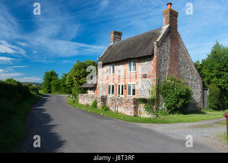 Tradizionale di pietra focaia con tetto in paglia e cottage di mattoni nel villaggio costiero di Chidham, West Sussex, Regno Unito Foto Stock