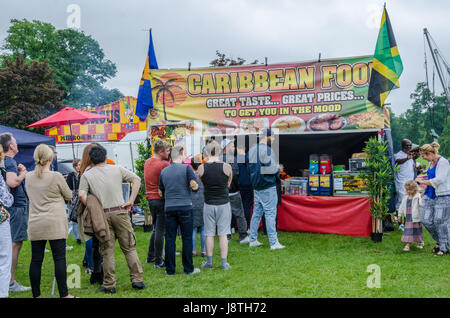 La gente in coda per acquistare cibo formano un cibo caraibico stallo a lettura Carnevale a Prospect Park, la lettura. Foto Stock