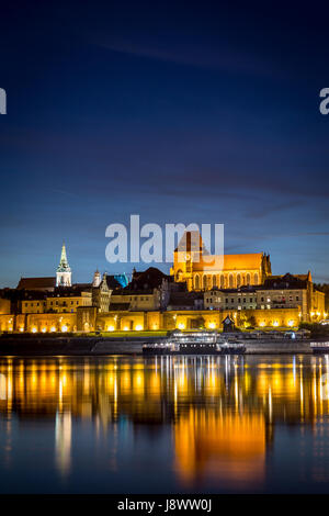 Panorama notturno di Torun, Polonia, panorama della citta' vecchia con le sue torri medievali. Riflesso nel fiume Vistola Foto Stock