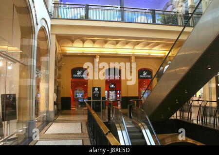 Xix secolo Neo Gothic Magna Plaza Shopping Mall a Nieuwezijds Voorburgwal, Amsterdam, Paesi Bassi. Interno con Swarovski Boutique.e scale mobili. Foto Stock