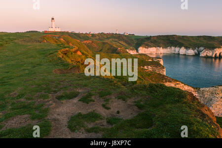 Il moderno faro ed erosione lungo le aspre scogliere di gesso affiancato dal Mare del Nord all'alba a Flamborough Head, Flamborough, nello Yorkshire, Regno Unito. Foto Stock