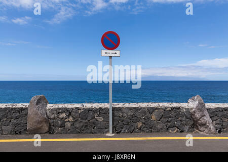 Linea gialla sulla strada e nessun segno di parcheggio accanto al muro di pietra naturale al litorale con l'Oceano Atlantico e l'isola di La Gomera in background, Foto Stock