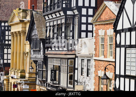 Inghilterra, Cheshire, Chester, Fila di edifici con un mix di stili architettonici su Eastgate Street. Foto Stock