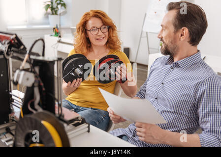 Felice donna positiva tenendo due spire del filamento Foto Stock