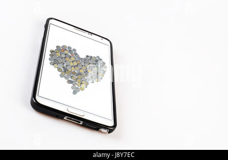 Smartphone con cuore a forma di moneta di sfondo e isolato su sfondo bianco Foto Stock