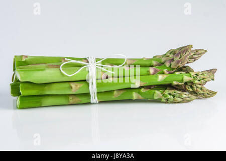 Un covone di asparagi su uno sfondo bianco isolato Foto Stock