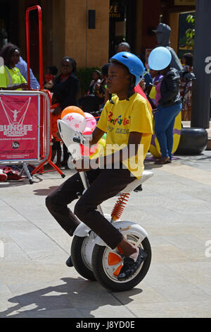 Uomo seduto sulla macchina Segway.Nairobi, Kenya Foto Stock
