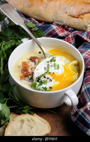 Aglio crema di patate Zuppa con pancetta e uova in camicia, erbe e spezie Foto Stock