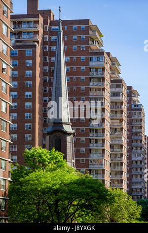 La guglia della chiesa dei Santi Apostoli in contrasto con la costruzione di terrazze di Penn Sud in Chelsea in estate. Manhattan, New York City Foto Stock
