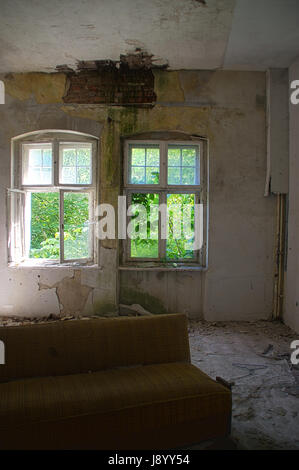 Distrutta camera in casa in rovina con alberi dietro la finestra Foto Stock