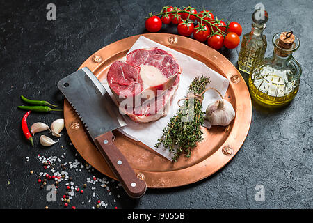 Materie Stinco di vitello fette di carne e gli ingredienti per Osso Buco cottura su sfondo nero, vista dall'alto Foto Stock