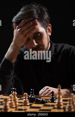 Ritratto di uomo adulto che capitolò nel gioco degli scacchi. Foto Stock