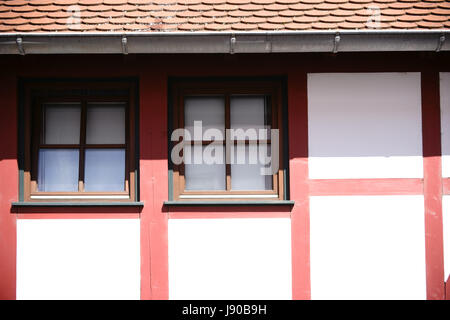 Close-up del fascio di costruzione di una casa in legno e muratura con windows in una forte luce del sole sotto il tetto. Foto Stock