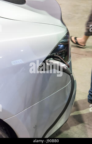 Il rifornimento di un elettrico Tesla model s auto. Foto Stock