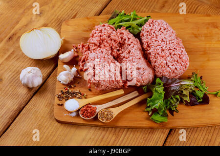 Freschi Fatti in casa materie la carne macinata per hamburger con spezie sul tavolo, Foto Stock