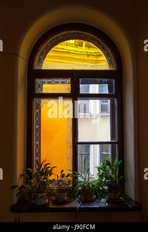 Vecchia finestra nella tromba delle scale con vetro macchiato Foto Stock