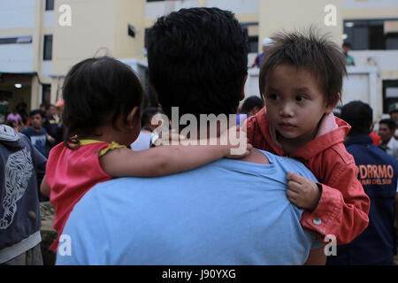 Lanao del Sur Provincia, Filippine. 31 Maggio, 2017. I bambini sono portati da un lavoratore di volontariato dopo che essi sono stati salvati dalle truppe governative durante una operazione di salvataggio in Lanao del Sur Provincia, Filippine, 31 maggio 2017. Venti i residenti sono stati liberati dalle truppe governative come continuano gli scontri contro il Maute gruppo militante. Credito: Rouelle Umali/Xinhua/Alamy Live News Foto Stock