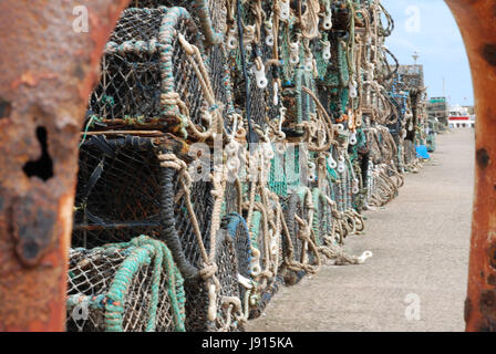 Il granchio aragosta / bicchieri impilati sulla banchina del porto di Bridlington, inquadrata tramite un arrugginito ringhiera. Fotografia è stata scattata nel 2012 Foto Stock