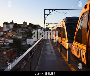 Ponte Dom Luís I durante il tramonto con metro gialla tram - Porto, Portogallo Foto Stock