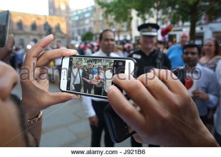 Un membro del pubblico fotografie capo di polizia Ian Hopkins e altri in St Ann's Square Manchester Foto Stock