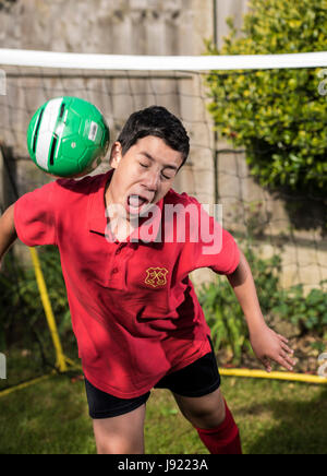 Le pratiche di Boy soccer in un giardino inglese Foto Stock