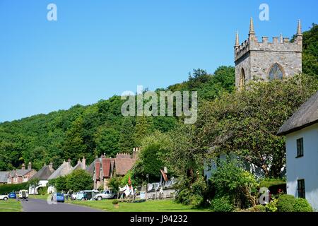 Vista lungo il grazioso villaggio di strada con la chiesa in primo piano, Milton Abbas, Dorset, Inghilterra, Regno Unito, Europa occidentale. Foto Stock
