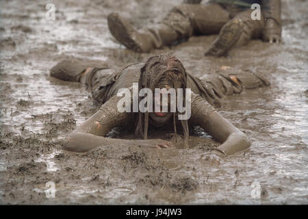 Glastonbury Festival 1998, uno degli anni peggiori per fanghi, dove i partecipanti del festival è andato a fango di balneazione tra guardare la musica dal vivo di atti. Il festival annuale attira fino a 175.000 persone per azienda agricola degna dove si può guardare spettacoli di musica dal vivo su numerosi stadi comprende la fase della piramide. Foto Stock