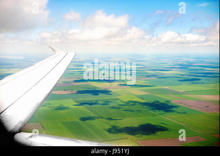 Ala di un aeroplano che vola al di sopra della terra. La vista da una finestra di aereo. Foto applicata al turismo operatori. Foto Stock