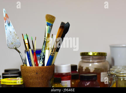 Multicolore di pennelli e colori in un artists' studio. Foto Stock
