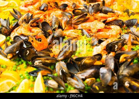 Borough Market London elegante sistemazione di fast food grande padella di paella Cozze Gamberi piselli riso fette di limone Limoni Foto Stock