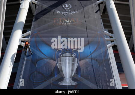 I lavoratori in discesa in corda doppia installazione ingranaggi di un banner al di fuori lo stadio nazionale del Galles (aka Principato Stadium) Foto Stock