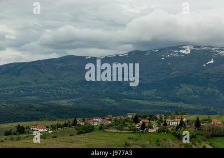 Quartiere residenziale del Villaggio bulgaro Plana nella foresta e vari alberi con nuove foglie e sbocciano i fiori di primavera, Plana mountain, Bulgaria Foto Stock