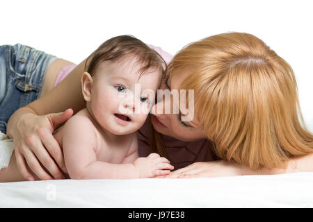 Carino madre abbraccia il suo piccolo bambino. Donna e bambino neonato boy rilassatevi in una camera bianca. Foto Stock
