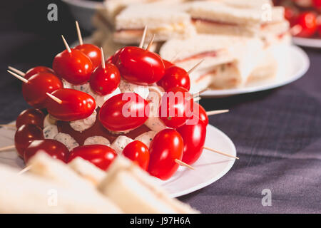 Cocktail di poco i pomodori con il formaggio sul picco su una piastra Foto Stock