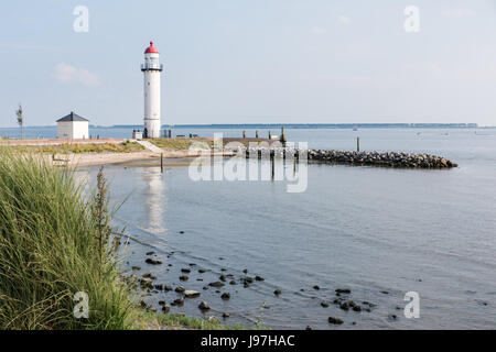 Lo storico faro di colore bianco con il caratteristico colore rosso rame top presso la riva del Haringvliet a Hellevoetsluis nel sud-ovest dell'Olanda. Foto Stock