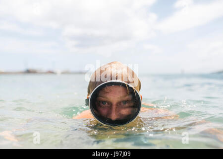 Uomo che indossa gli occhiali per nuoto nuoto in mare Foto Stock