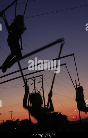 Sagome di ragazze saltando su trampolini; bungee jumping Foto Stock